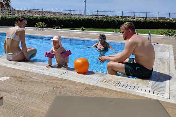 Mappa, pappa, mormor och morbros tillsammans i poolen.