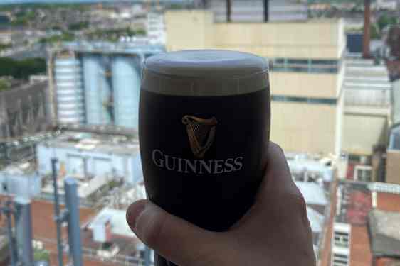 En hand som håller i ett glas Guinness.