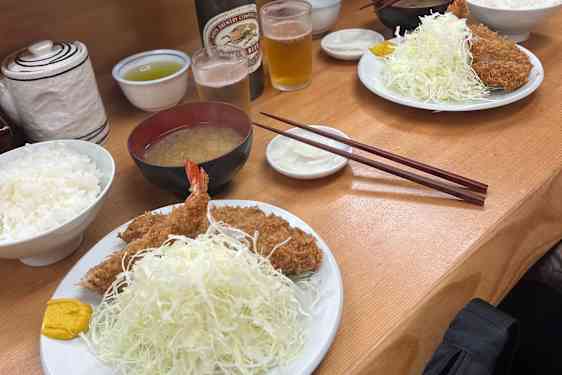 Saftigt, friterat fläsk och scampi, serverat med finstrimlad kål, ris och tonkatsu-sås