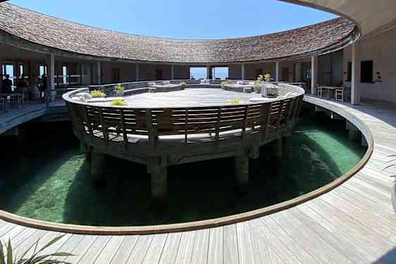 Rund träbyggnad med rund öppning för havet i mitten