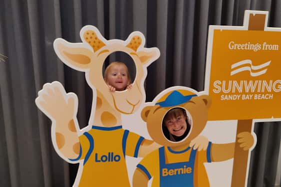 Mamma och dotter tittar ut genom Lollo & Bernie-pappfigurer.