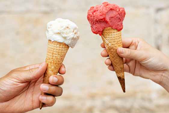 Två händer håller i varsin glass