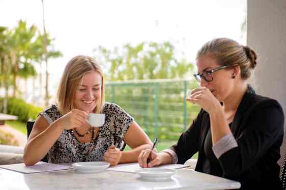 Två kvinnor dricker kaffe