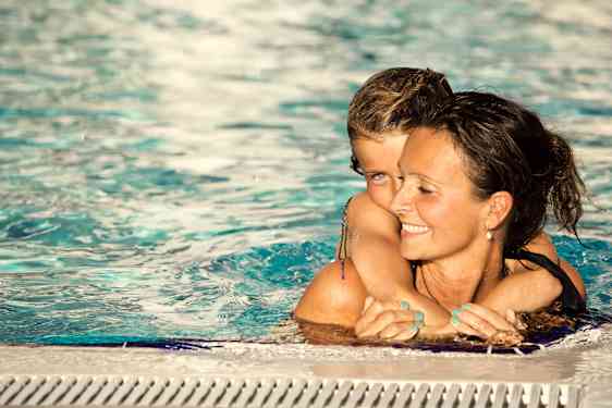 Mamma och dotter som badar i poolen