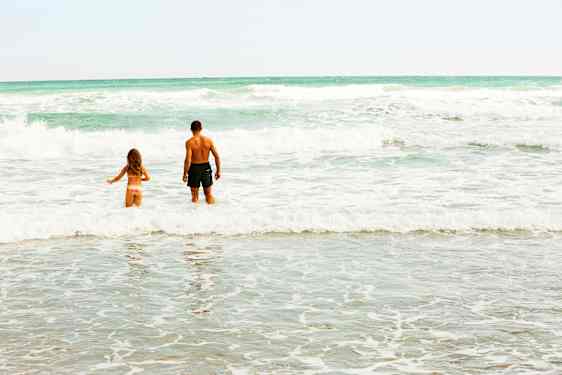 Barn och morfar badar i havet