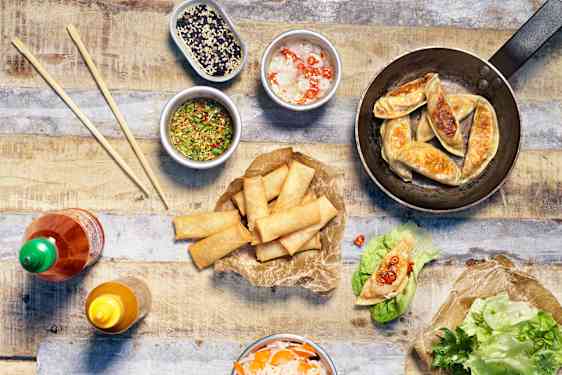 Dumplings och spring rolls i salladsblad med dipp och pickles
