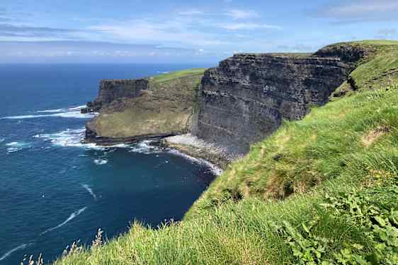 Cliffs of Moher – gröna klippor vid ett blått hav.