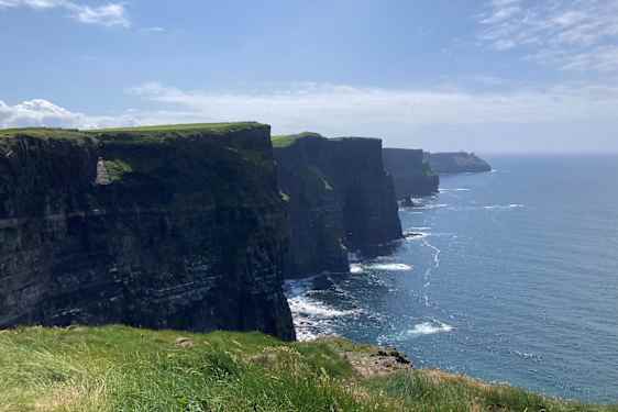 Cliffs of Moher – gröna klippor vid ett blått hav.