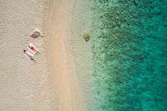 En vit sandstrand med turkosblått vatten