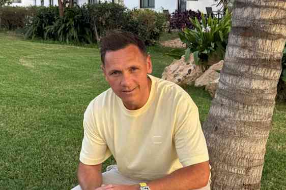 Joakim Hykkerud lutar sig mot en palm