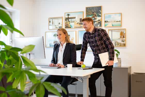 Två personer pratar vid ett skrivbord