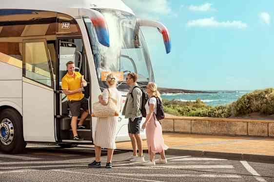 Tre personer möter en guide vid en transferbuss