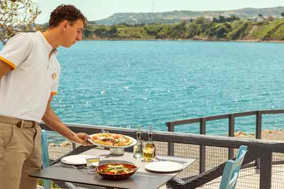 servitör serverar mat vid havet