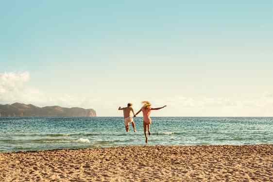 Par som springer på stranden i Mallorca
