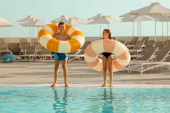 Barn med badringar vid pool