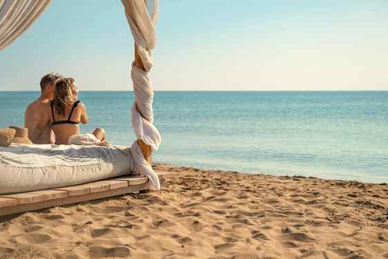 Par sitter på en balisäng på stranden 