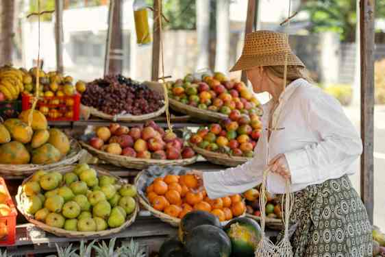 Kvinna köper frukt från en kiosk