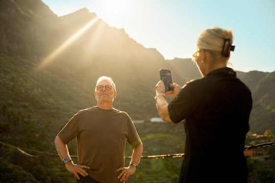 Två personer tar kort vid ett berg