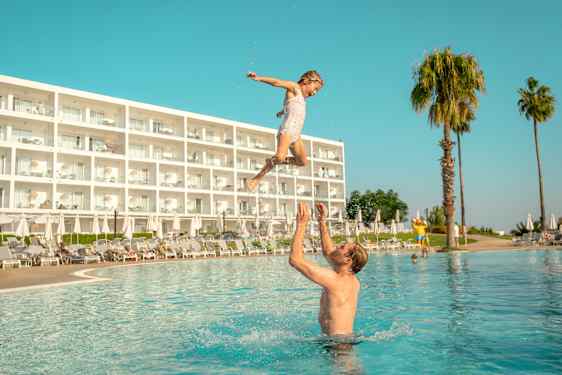 Pappa och dotter leker i en pool