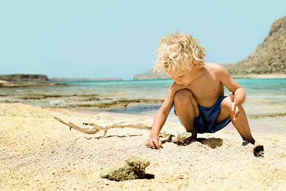 Kille leker på stranden
