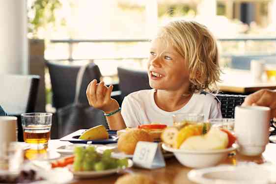 Pojke sitter och äter frukost