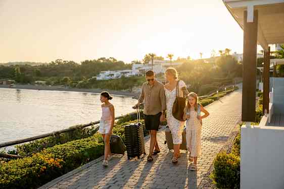 Familj går med resväskor