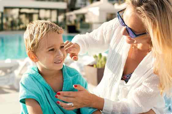 mamma och dotter äter pizza på stranden