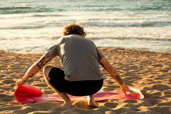 man gör yoga på stranden