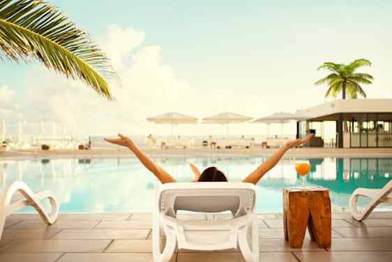 Kvinna kopplar av vid poolen