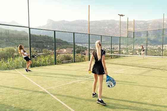 Tre tjejer spelar padel.