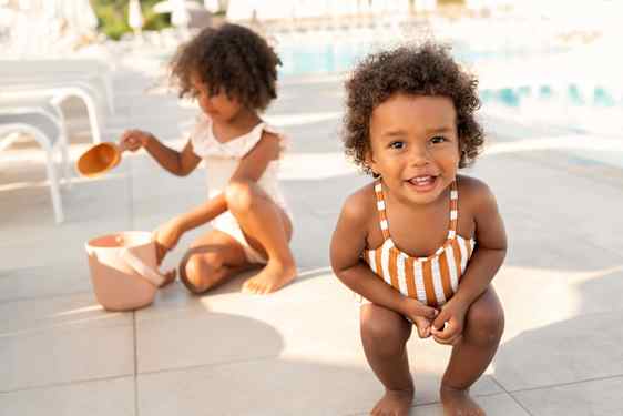 Två flickor leker vid poolområde