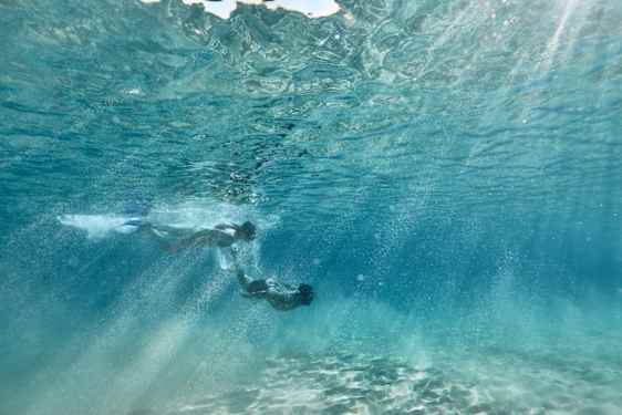 Man och kvinna som dyker under ytan.