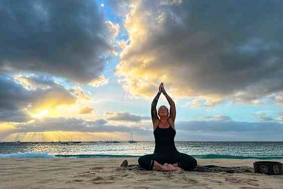 Emma Guldner gör yoga på en strand