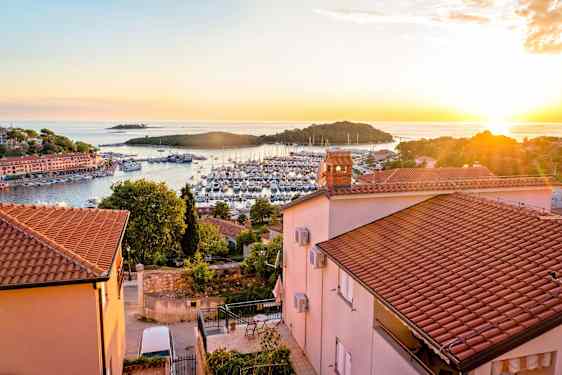 Solnedgång i Vrsar med utsikt över hamnen och ön Sveti Juraj.