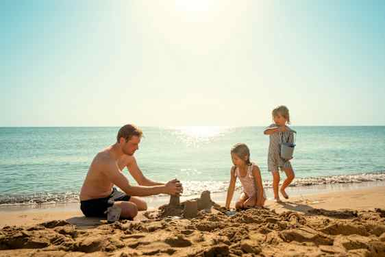 Familie leger på stranden