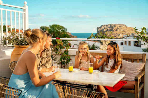 Familj har mysigt på restaurang med utsikt över havet