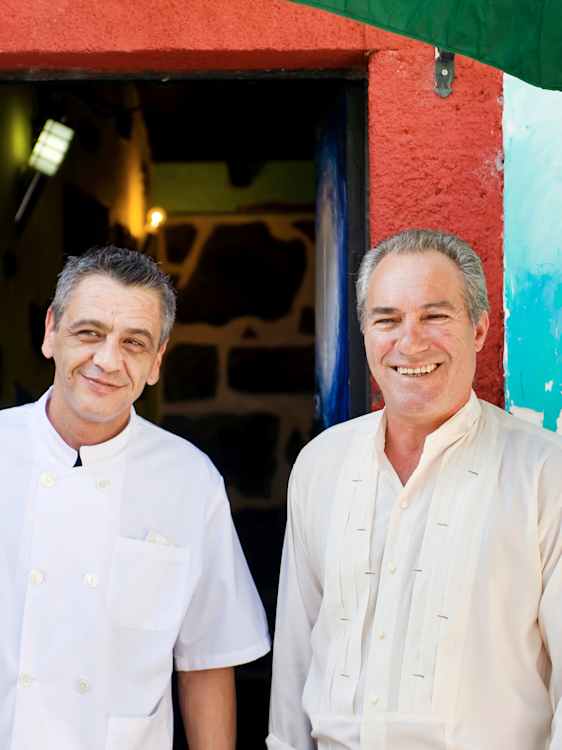 Kock och servitör framför restaurang