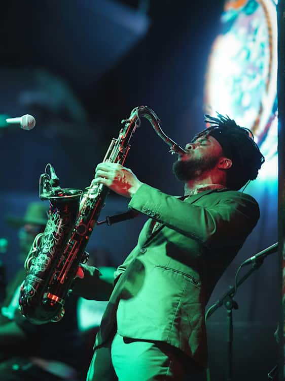 Man på bar spelar saxofon