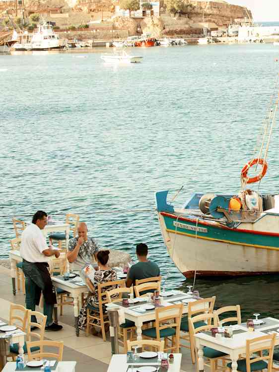 Restaurang vid havet med fiskebåt utanför