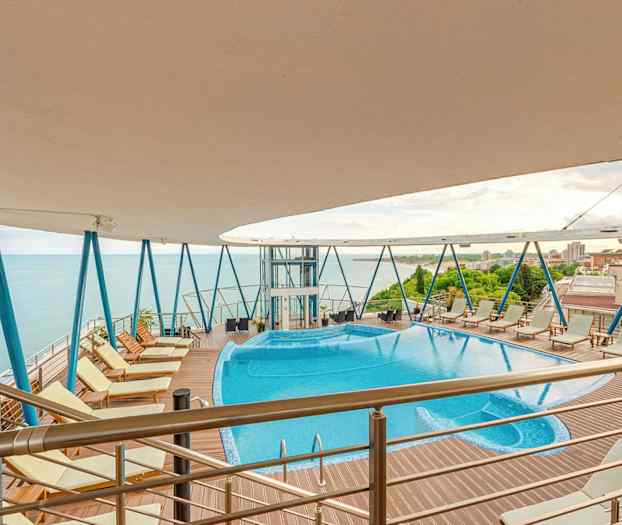 Utomhuspool med bubbelpool på högt däck med havsutsikt. (AI-genererad text)