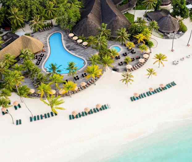 Flygfoto av en strand med solstolar, parasoller och en pool omgiven av palmer. (AI-genererad text)