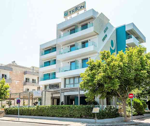 En modern hotellbyggnad med fem våningar och balkonger, omgivna av träd. (AI-genererad text)