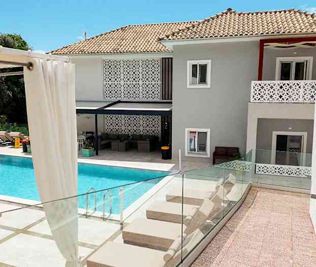 En modern villa med swimmingpool och solstolar. (AI-genererad text)