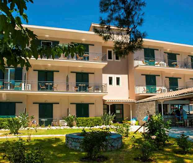 Exteriör av ett trevånings bostadskomplex med balkonger och omgivande trädgård. (AI-genererad text)