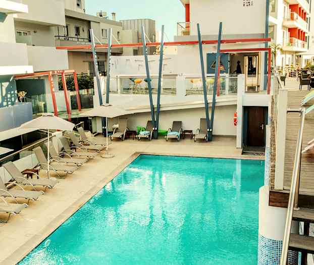 Utomhuspool vid ett modernt hotell med solstolar och parasoller. (AI-genererad text)