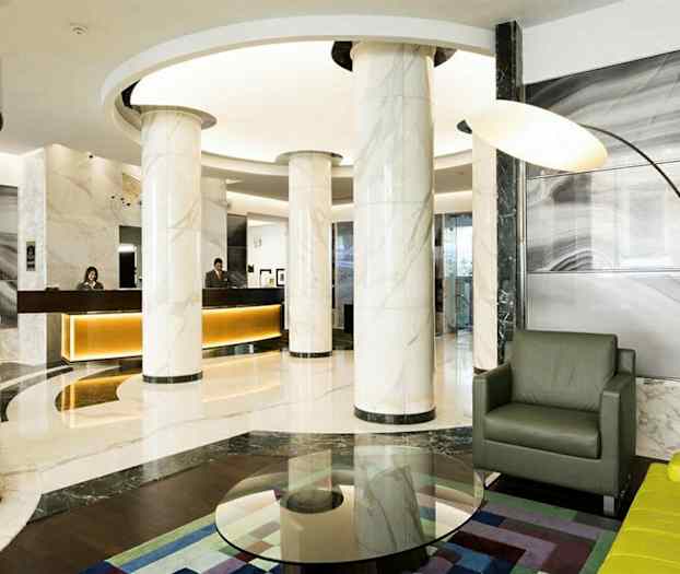 Modern hotellobby med marmorpelare, receptionsdisk och sittgrupp. (AI-genererad text)