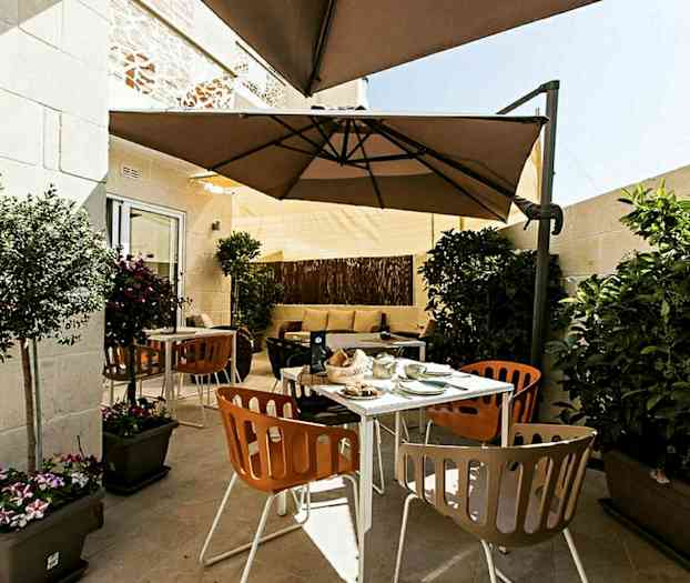 En terrass med utemöbler, parasoll och växter. (AI-genererad text)