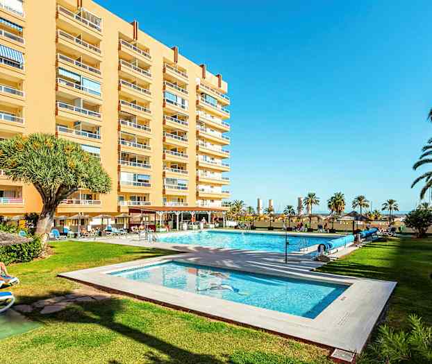 Hotellbyggnad med pool och trädgård. (AI-genererad text)