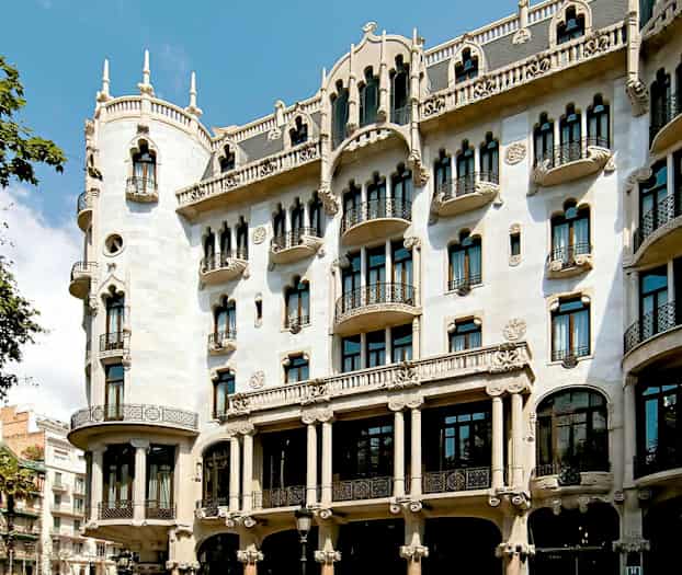 En bild av en dekorativ byggnad med ornamenterad fasad, balkonger och välvda fönster. (AI-genererad text)