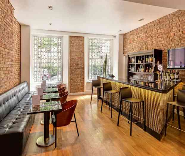 Modernt designad bar med sittplatser och tegelväggar. (AI-genererad text)